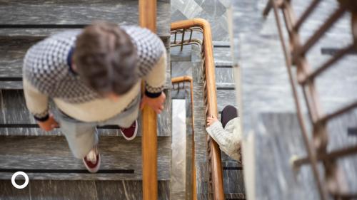 a woman walking down some stairs with a skateboard at Center Hotels Skjaldbreid in Reykjavík