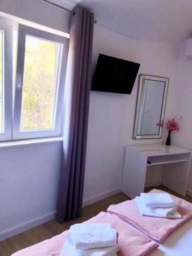 um quarto com uma cama com um espelho e uma janela em Hotel B&B CHAMBERLAIN em Hvar
