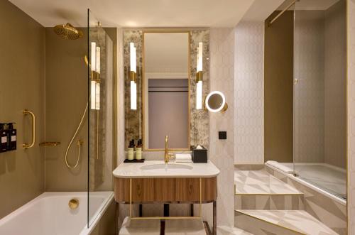 a bathroom with a sink and a shower and a tub at Hotel Saski Krakow Curio Collection by Hilton in Kraków