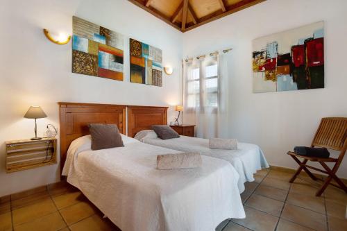 Dos camas en una habitación con paredes blancas. en Villa Brisamar19, en Corralejo