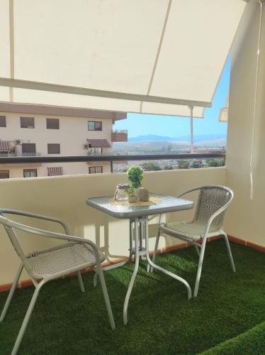 d'une table et de deux chaises sur un balcon avec vue. dans l'établissement ALMIJARA, à Vélez-Málaga