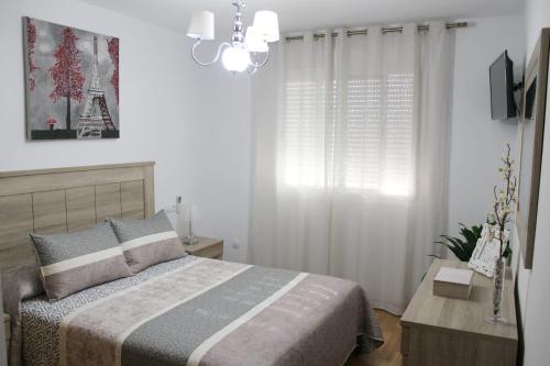 - une chambre avec un lit et un lustre dans l'établissement ALMIJARA, à Vélez-Málaga