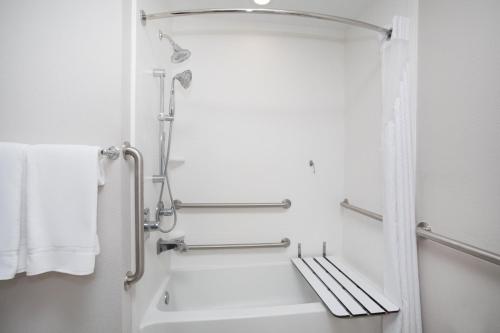 Holiday Inn Express Slidell, an IHG Hotel في سليدل: حمام مع دش وحوض استحمام أبيض