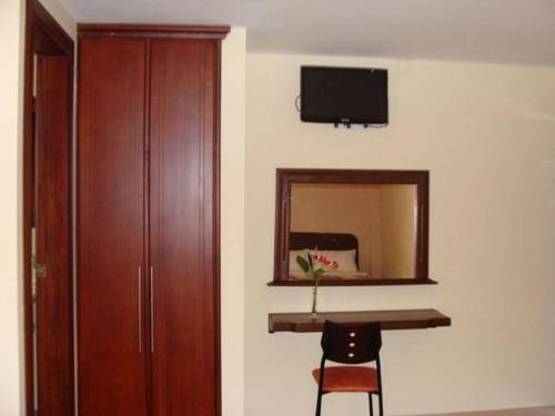 a room with a desk and a mirror and a cabinet at Hostal La Molienda in Puyo