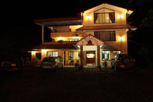 a house with two cars parked in front of it at night at Hostal La Molienda in Puyo