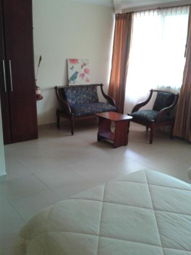 a living room with a couch and a chair at Hostal La Molienda in Puyo