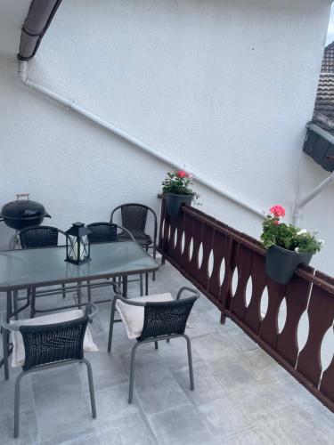 a patio with tables and chairs and flowers at Relaxen im alten Winzerhaus Fewo OG in Rech
