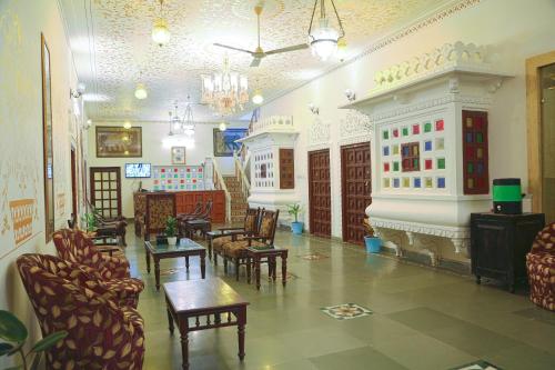 a living room with chairs and a fireplace in a building at Hotel Darbargarh A Unit of Khamma Ghani A Boutique Hotel in Udaipur
