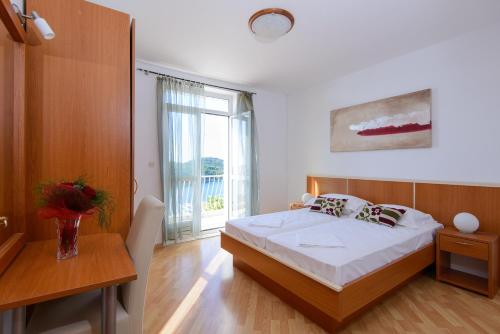 a bedroom with a bed and a table and a window at Sunset Apartment in Zaton