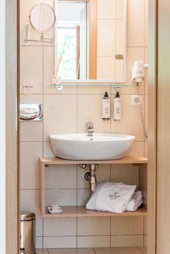 a bathroom with a sink and a mirror at Kerpė Hotel & SPA in Palanga