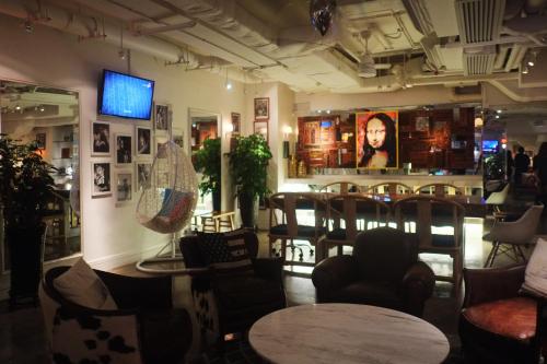 a room with chairs and tables and a bar at Mini Hotel Causeway Bay in Hong Kong