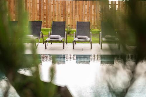 a group of chairs sitting next to a pool at Hotel Königsleiten Vital Alpin in Königsleiten