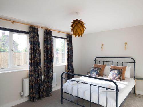 a bedroom with a bed and two windows at Pass the Keys Stunning 3 Bedroom Home with Free Parking in Bridgwater