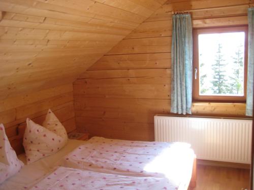 a bedroom with a bed in a wooden cabin at Almhütte Tschiernock in Seeboden