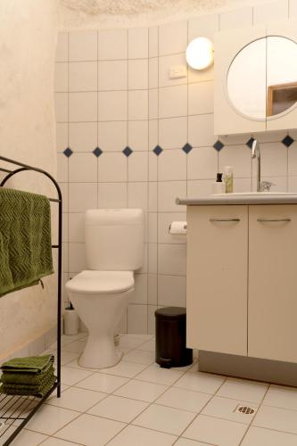 a white bathroom with a toilet and a sink at Ali's Underground Home in Coober Pedy