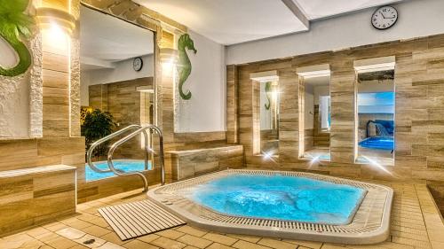 a jacuzzi tub in a room with two mirrors at St Lukas Medical & SPA in Świeradów-Zdrój