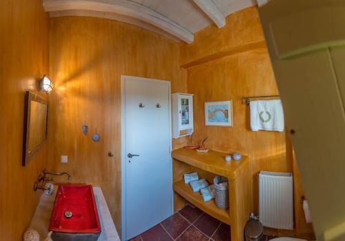 a bathroom with a red toilet and a sink at Villa Dimitra - Mani , traditional archontiko in Dhirós