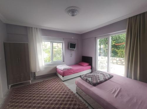 1 dormitorio con 2 camas y ventana en Kaplan Apart - Pansiyon en Yeşilova