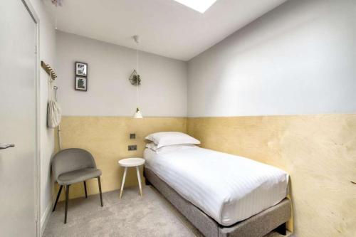 a bedroom with a bed and a chair in it at The Castle Hotel in Berwick-Upon-Tweed