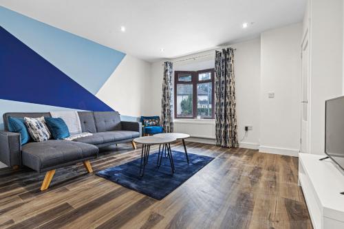a living room with a couch and a table at Walsall - 4 Bedroom House, Wi-Fi, Garden , Sleeps 8 - JRR Stays in Bescot