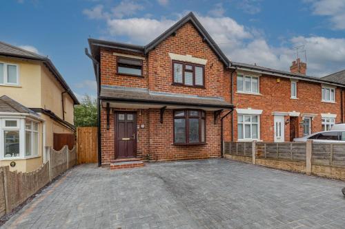 a brick house with a driveway in front of it at Walsall - 4 Bedroom House, Wi-Fi, Garden , Sleeps 8 - JRR Stays in Bescot