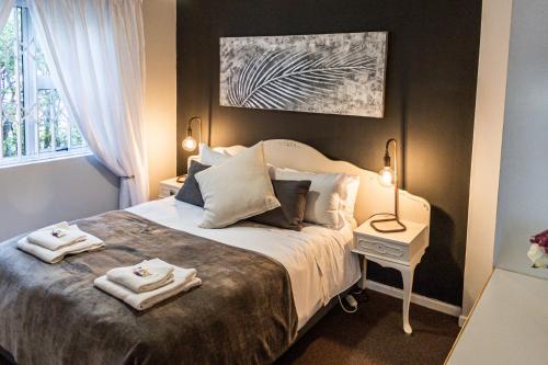 a bedroom with a bed with two towels on it at Seagull Apartment Hermanus in Hermanus