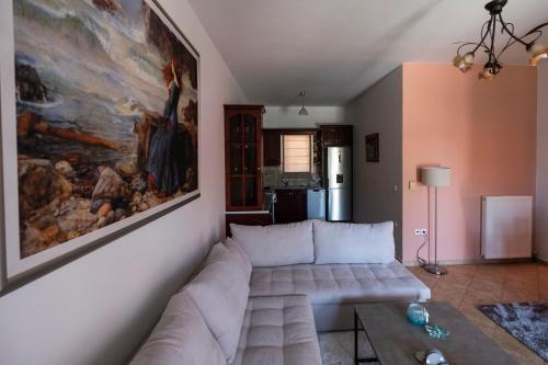a living room with a couch and a painting on the wall at Τα ανετα διαμμερισματα του Λεκα in Zakharo