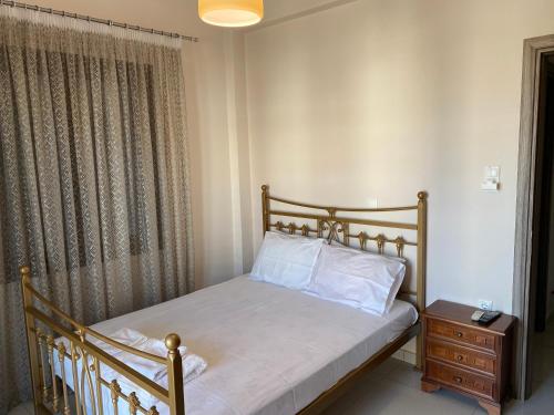 a small bedroom with a bed and a night stand at Saronic Hearts in Agioi Theodoroi