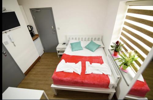倫敦的住宿－London Suite，一间卧室配有一张带红色毯子的床