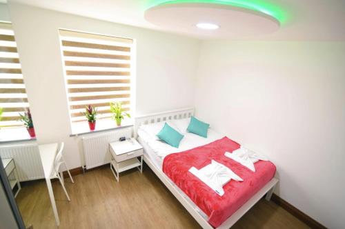 a bedroom with a bed with a red blanket at London Suite in London