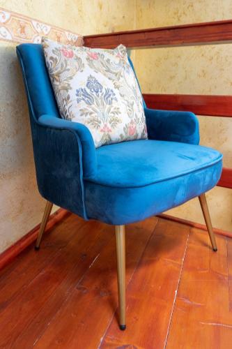 a blue chair with a pillow on a wooden floor at LA CASETTA - Mon Petit Chalet in Miranda