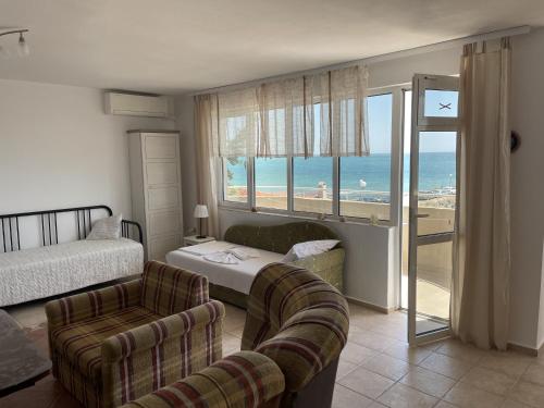 a bedroom with a bed and a couch and a window at Apartments Panorama Ravda in Ravda