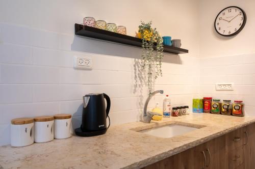 a kitchen counter with a coffee maker and a sink at ירוק באלה - דירת נופש ברמת ישי in Ramat Yishay