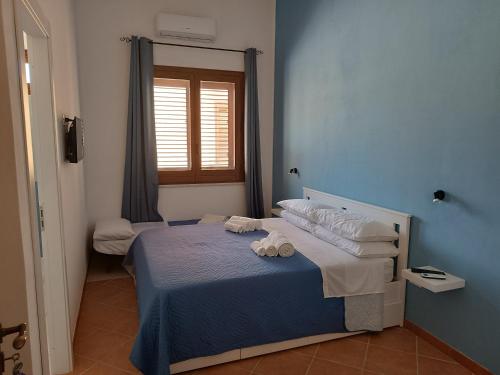 a blue bedroom with a bed with towels on it at Bed & Breakfast Ilary in Marsala
