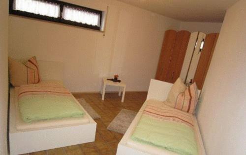 a room with two beds and a table with a window at Ferienwohnung Erika in Grenzach-Wyhlen
