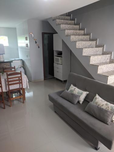 sala de estar con sofá y escalera en Duplex Cabo frio I en Cabo Frío