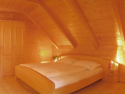 a bed in a room with a wooden ceiling at Almhüttendorf Klippitztörl in Klippitztorl