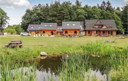 a log house with a pond in front of it at Nice Home In Ustka With Wifi in Ustka