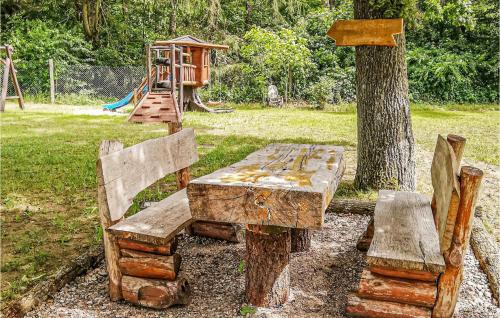 a wooden table and two benches next to a playground at Nice Home In Ustka With Wifi in Ustka