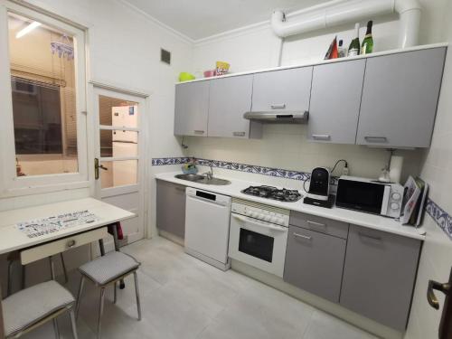 een keuken met witte kasten en een fornuis met oven bij ACOGEDOR Y LUMINOSO PISO CÉNTRICO in Vigo