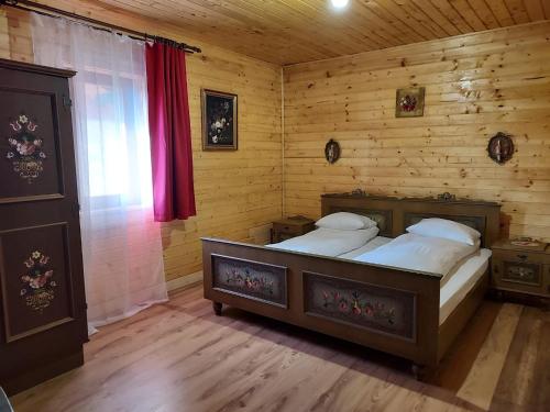 a bedroom with two beds in a log cabin at Country Chalet in Praid