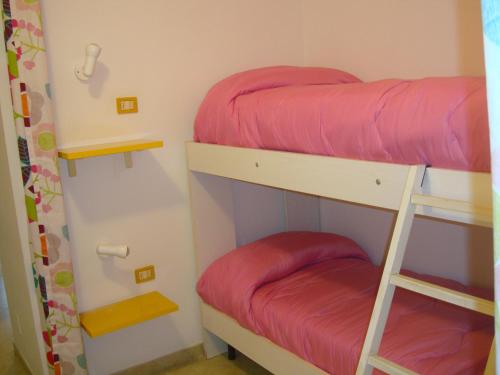 2 Etagenbetten in einem Zimmer mit roter Bettwäsche in der Unterkunft Aurora e Andrea San Vito lo Capo in San Vito lo Capo