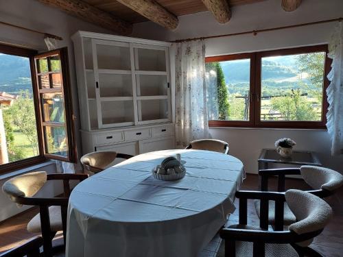 a dining room with a table and chairs and windows at Country Chalet in Praid