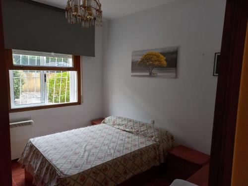 een kleine slaapkamer met een bed en een raam bij ACOGEDOR Y LUMINOSO PISO CÉNTRICO in Vigo