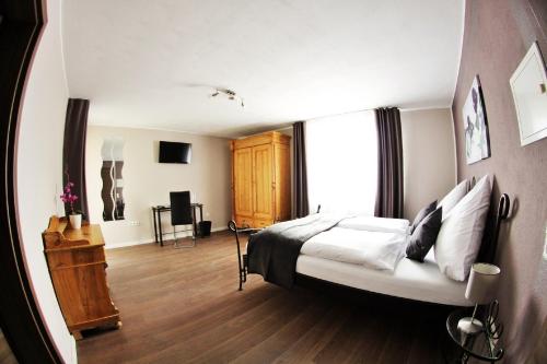 Apado-Hotel garni في هومبورغ: غرفة نوم بسرير ونافذة كبيرة