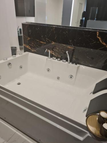 a bathroom with a white tub with a black counter top at Maliziusella in Naples