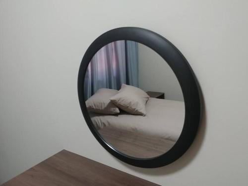 a mirror on a wall with a bed and pillows at Ebeneezer Self-Catering Guesthouse in the Lowveld in Sabie