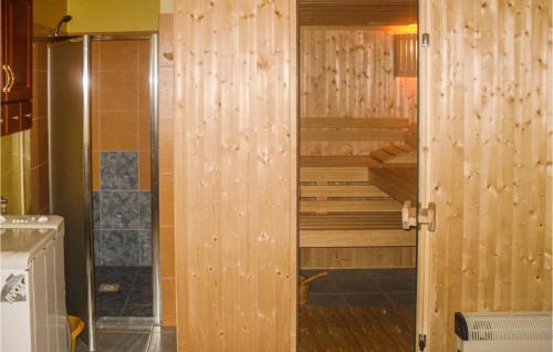 ein Bad mit einer Dusche und einer Holzwand in der Unterkunft Stunning Home In Nowe Warpno With 5 Bedrooms And Sauna in Nowe Warpno