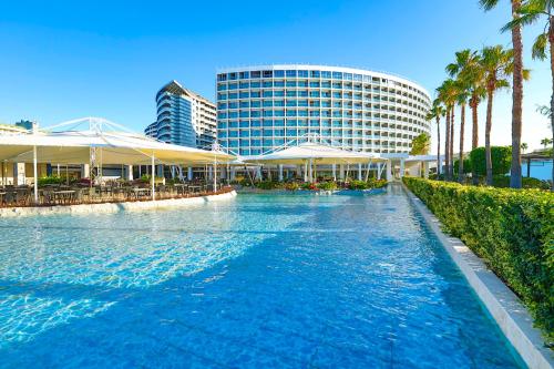 een zwembad tegenover een hotel met palmbomen bij Crystal Centro Resort - Ultimate All Inclusive in Lara