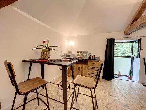 a desk and chairs in a room with a window at Magnifique et confortable loft in Marlieux